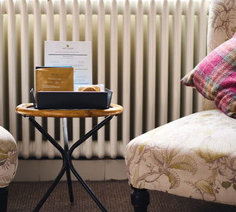 In a hotel room, Artisan Coffee bags and paired chocolates sitting in a display case next to a pod machine