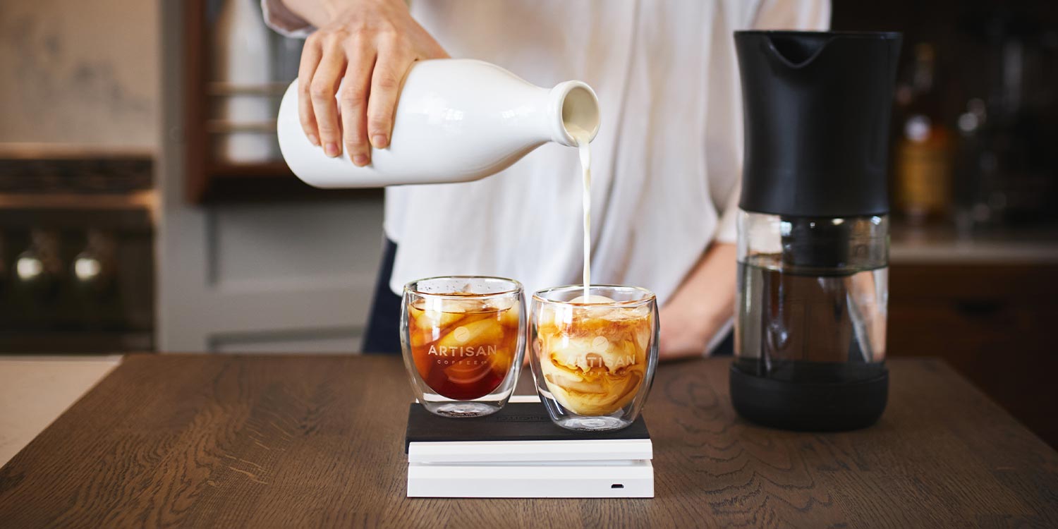 artisan coffee co milk pouring into coldbrew whisky tumbler with scales