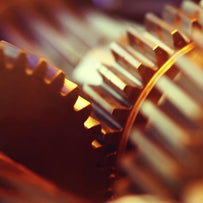 Two copper cogs are in motion, used here in reference to the 720 cogs used in the Enigma machine