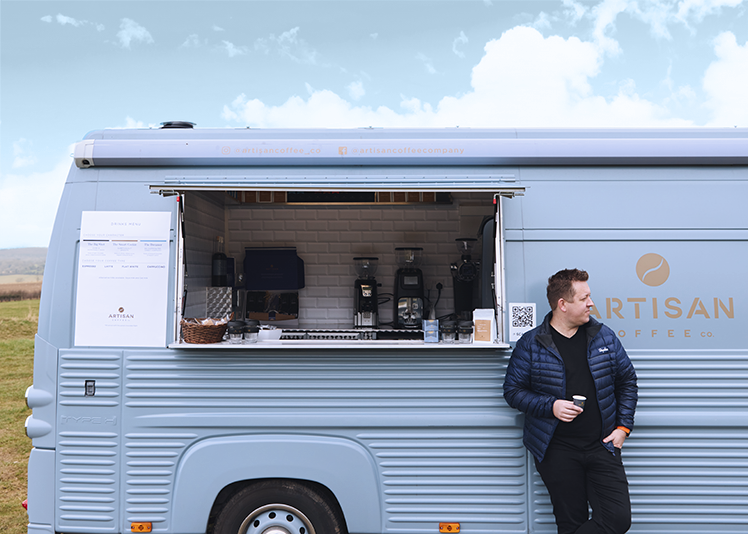 Ashley Palmer-Watts standing with Arty, our coffee van