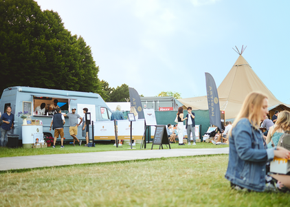 Arty the coffee van in a fields at an event with people enjoying coffee