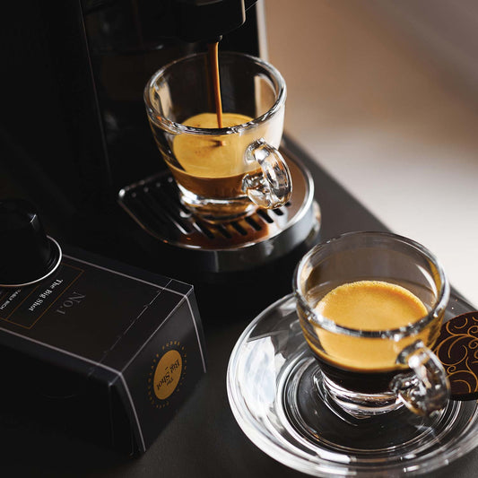 The Big Shot Nespresso compatible coffee pods with coffee pouring from a pod machine